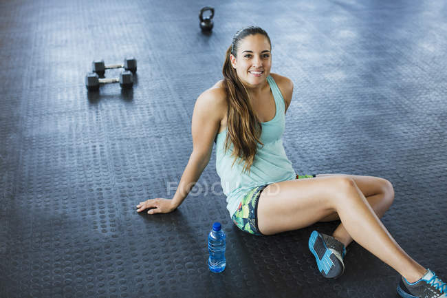 Портрет усміхнений, впевнена молода жінка відпочиває пост тренування в спортзалі — стокове фото