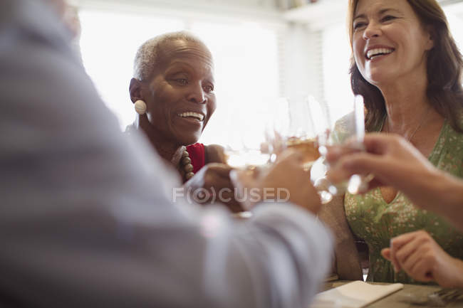 Mujeres maduras sonrientes bebiendo vino, cenando en el restaurante - foto de stock