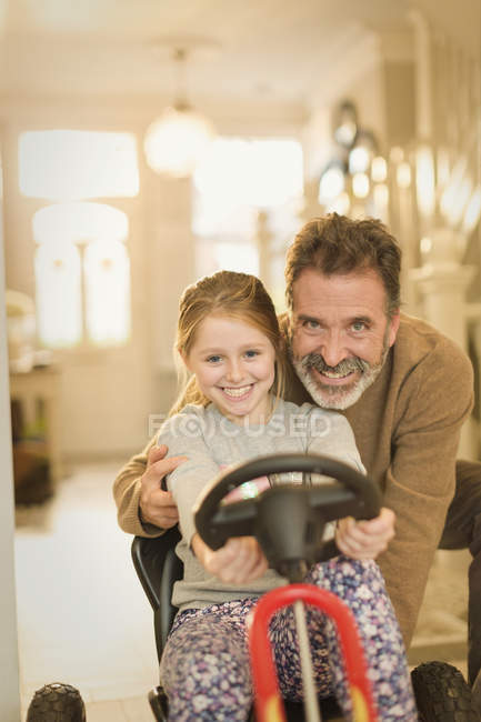 Retrato sonriente padre e hija vinculación, jugando con coche de juguete - foto de stock