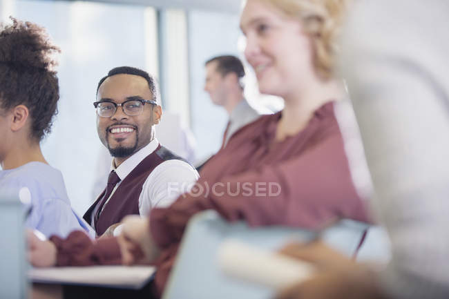 Lächelnder Geschäftsmann hört Konferenzbesucher zu — Stockfoto