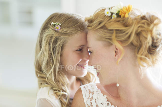 Bride and bridesmaid facing each other smiling — Stock Photo