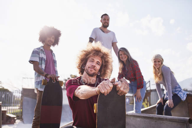 Portrait cool friends with skateboards at sunny skate park — Stock Photo