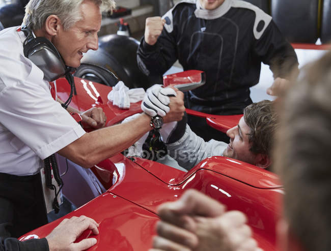 Manager e pilota di Formula 1 stringono la mano, celebrando la vittoria — Foto stock