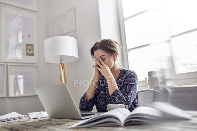 Stanca, donna d'affari stressata al computer portatile con la testa in mano — Foto stock