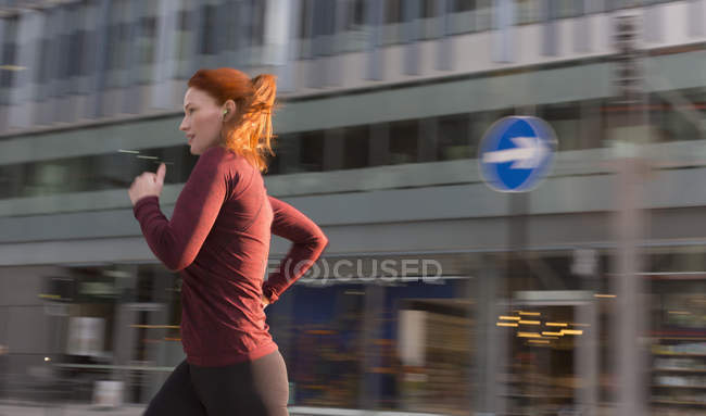 Бегущая женщина по городскому зданию — стоковое фото