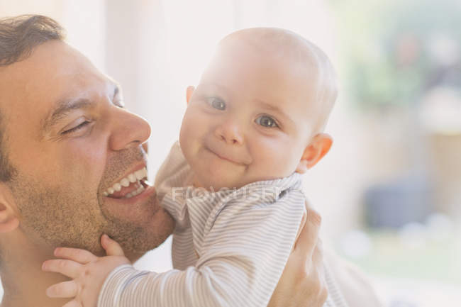 Retrato feliz padre sosteniendo lindo bebé hijo - foto de stock