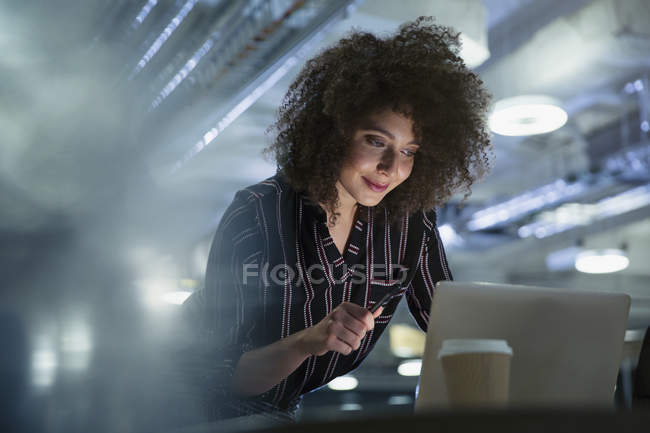 Femme d'affaires travaillant tard à l'ordinateur dans le bureau — Photo de stock