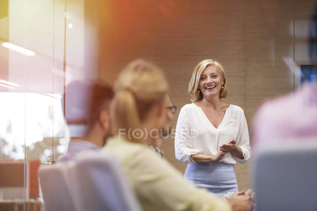 Smiling businesswoman leading meeting in conference room — Stock Photo