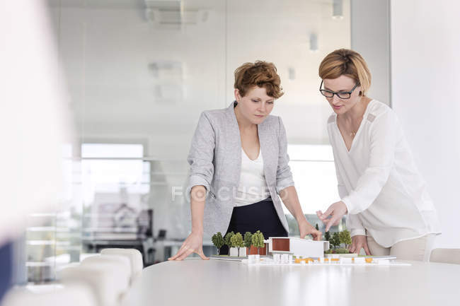 Female architects discussing model in conference room — Stock Photo