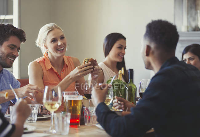 Друзья разговаривают и обедают за столом ресторана — стоковое фото