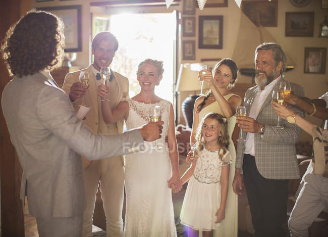 Giovane coppia e ospiti brindare con champagne al ricevimento di nozze — Foto stock