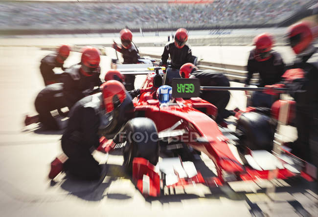 Екіпаж ями замінив шини на формулі одного гоночного автомобіля на піт-лейні — стокове фото