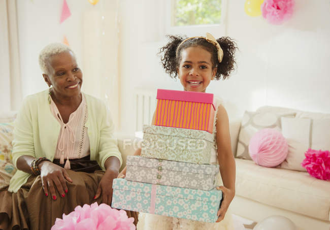 Porträt lächelndes Mädchen mit Stapel von Geburtstagsgeschenken — Stockfoto
