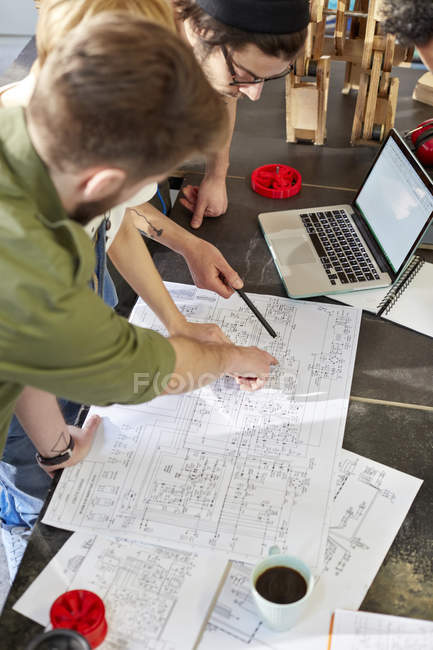 Designers meeting, reviewing plans in workshop — Stock Photo