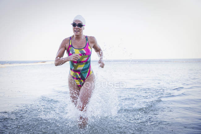 Nuotatrice attiva femminile che corre all'aperto sull'oceano — Foto stock