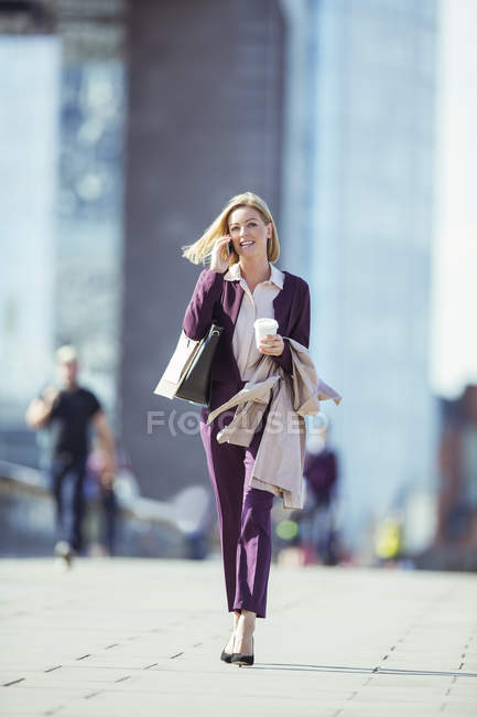 Businesswoman talking on cell phone in city — Stock Photo