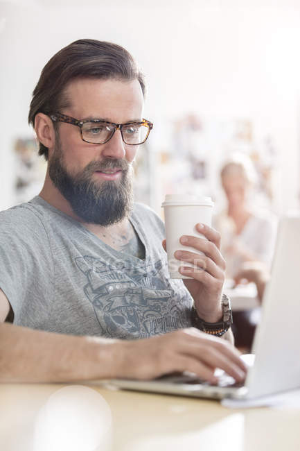 Disegno maschile professionale bere caffè di lavoro al computer portatile — Foto stock