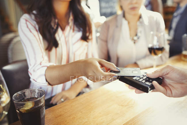 Mulher que paga bartender com cartão de crédito pagamento sem contato no bar — Fotografia de Stock