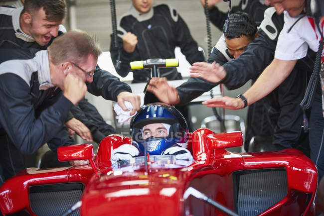 Gerente e equipe pit parabenizando fórmula um piloto de carro de corrida — Fotografia de Stock