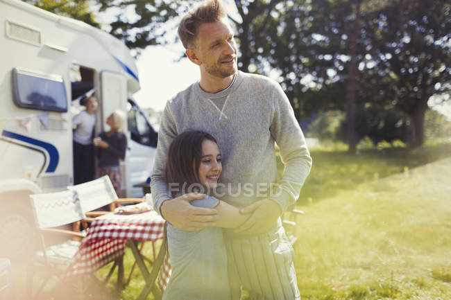 Liebevoller Vater und Tochter umarmen sich vor sonnigem Wohnmobil — Stockfoto