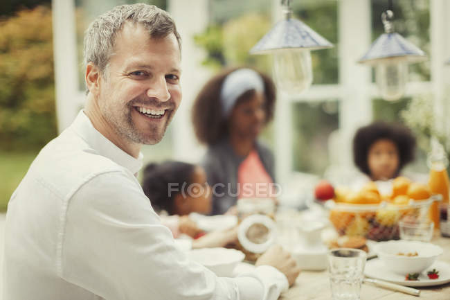 Retrato pai entusiasta com a família na mesa de café da manhã — Fotografia de Stock