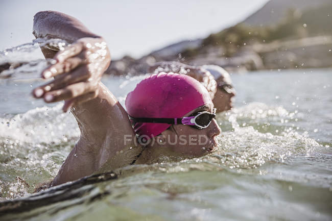 Решительная женщина плавает в открытом море в солнечном океане — стоковое фото