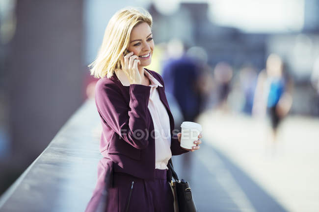 Donna d'affari che parla al cellulare sul ponte urbano — Foto stock