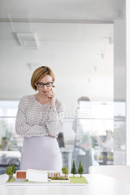 Женщина-архитектор рассматривает модель в конференц-зале — стоковое фото