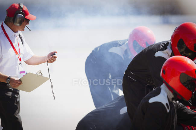 Менеджер с секундомером Формула 1 тренировка команды — стоковое фото