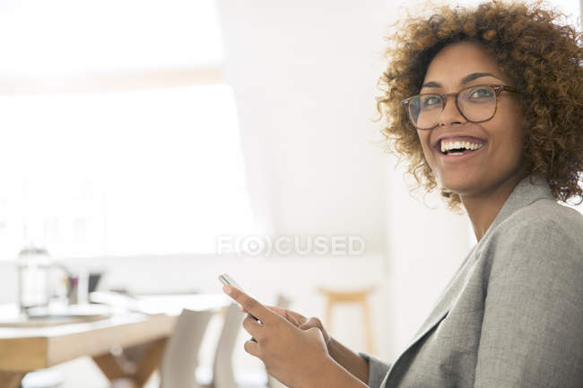 Retrato del trabajador de oficina sonriente con teléfono inteligente - foto de stock