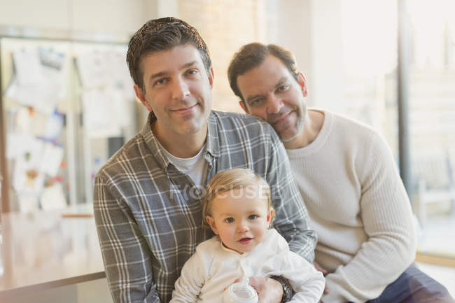 Retrato sonriente macho gay padres con bebé hijo - foto de stock