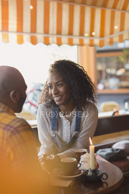 Affectionate couple holding hands and talking in cafe — Stock Photo