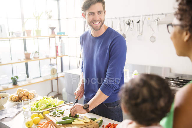 Famille heureuse préparant le repas dans la cuisine domestique — Photo de stock