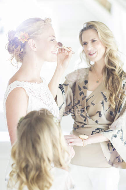 Ehrenmatronin überprüft Brautschminke vor der Trauung — Stockfoto