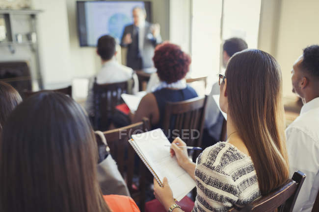 Empresária em audiência tomando notas em conferência de negócios — Fotografia de Stock