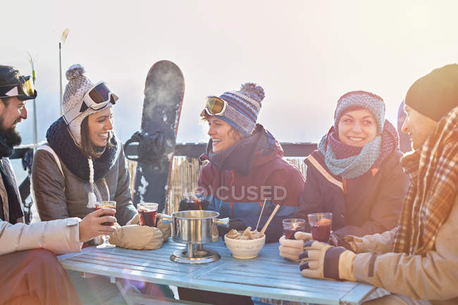 Snowboarder friends drinking cocktails on sunny balcony apres-ski — Stock Photo