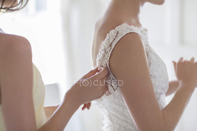Подружка нареченої, допомагаючи нареченої з соусом у внутрішній номер — стокове фото