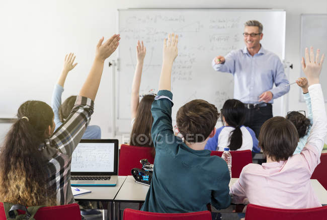 Profesor masculino llamando a los estudiantes en el aula - foto de stock