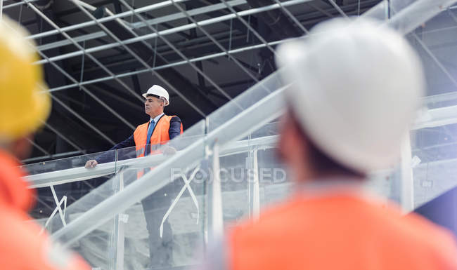 Geschäftsmann mit Hut schaut über Baustelle — Stockfoto
