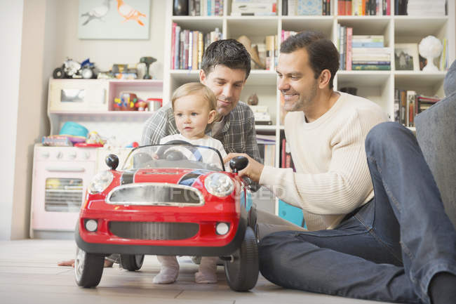 Mâle gay parents et bébé fils jouer avec jouet voiture — Photo de stock