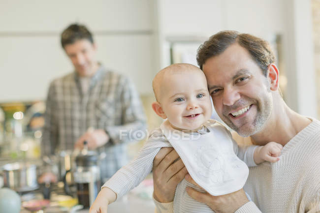 Retrato sorrindo gay pai segurando bonito bebê filho — Fotografia de Stock