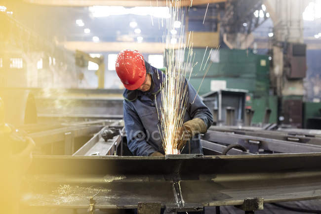 Welder using welding torch in steel factory — Stock Photo
