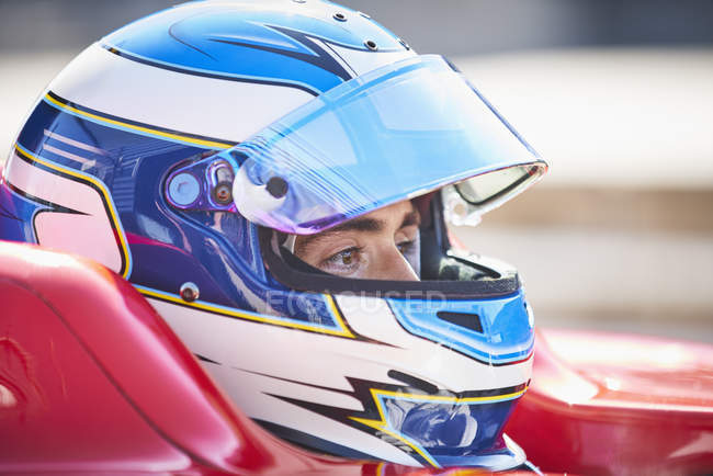 Close up formula one race car driver in helmet looking away — Stock Photo