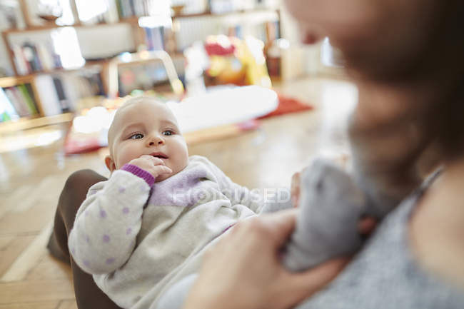 Mother holding baby daughter in lap — Stock Photo