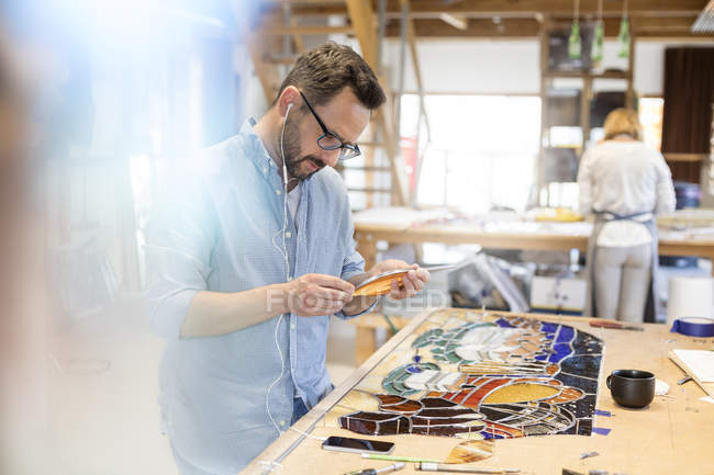 Stained glass artist working in studio — Stock Photo