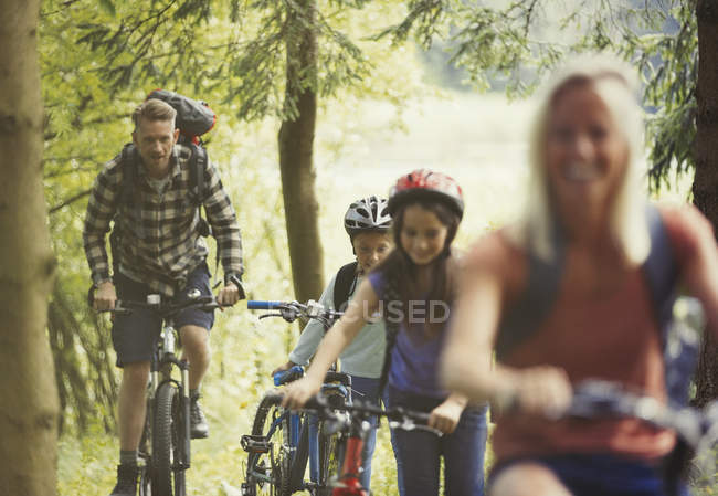 Family mountain biking in woods — Stock Photo