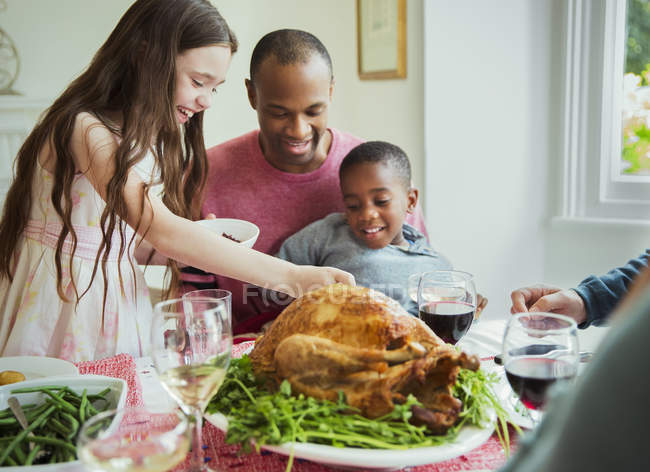 Famiglia multietnica che si gode la cena di Natale con tacchino a tavola — Foto stock