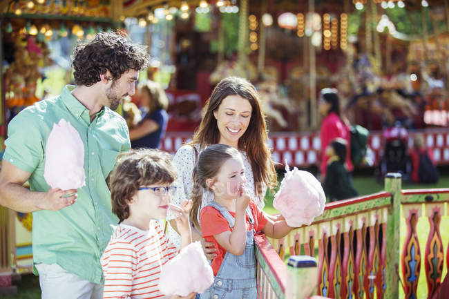 Família com fio dental rosa doce no parque de diversões — Fotografia de Stock