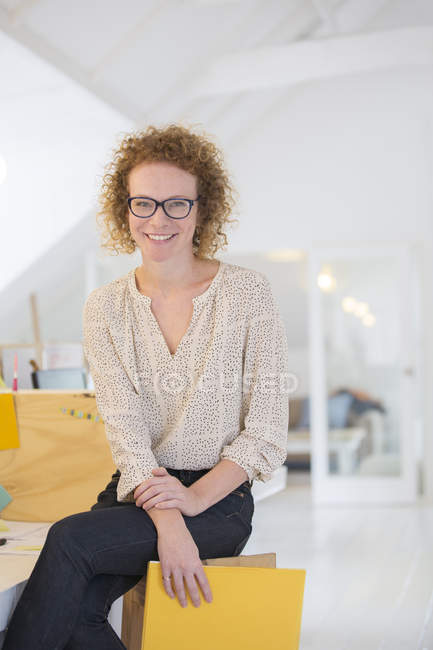 Portrait of laughing office worker holding file — Stock Photo
