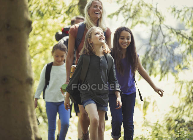 Sonriente familia senderismo en el bosque - foto de stock